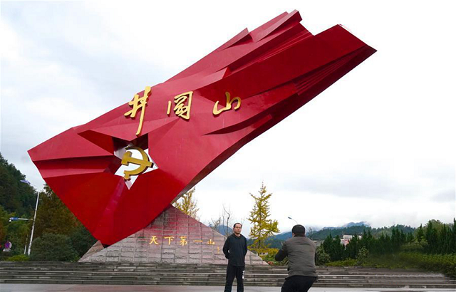 25x游客在井冈山的“井冈红旗”雕塑前参观留影.png