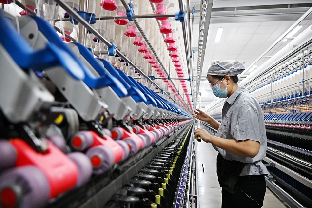 12r4月9日，在位于青岛市即墨区龙山街道的青岛即发纺织科技有限公司智慧纺纱生产线上，工人在生产高端纤维。.jpg