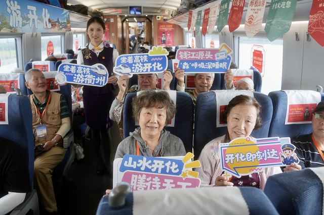 20YC3631次列车车厢里，杭州客运段铁路工作人员邀请旅客拍照打卡，现场互动氛围热烈。.jpg